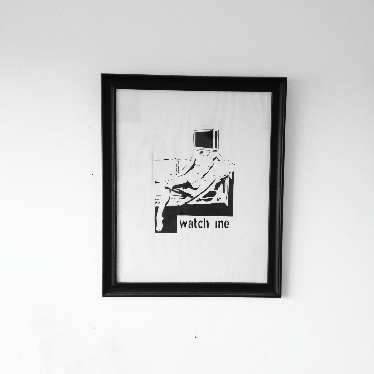 Framed stencil graffiti art depicting a nacked woman sitting on a sofa with an old TV for a head and the caption: watch me