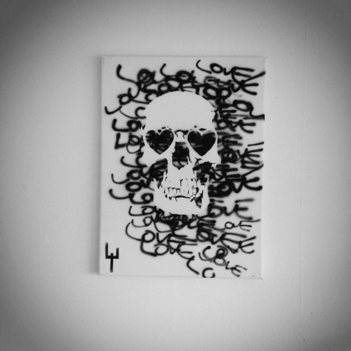 Canvas with stencil graffiti art with handwritten words love forming a skull with hearts as eyes