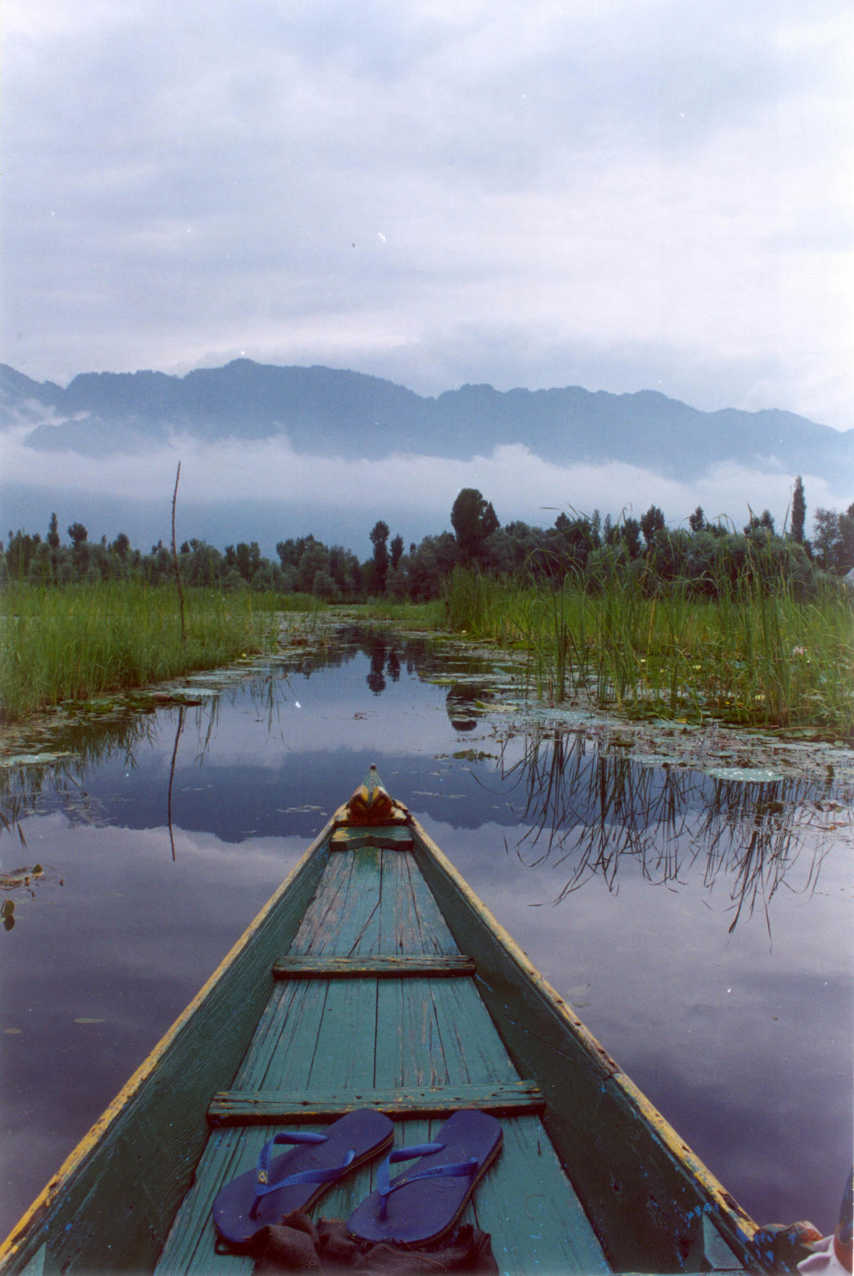 The front of a wooden boat on a lake in Kashmir